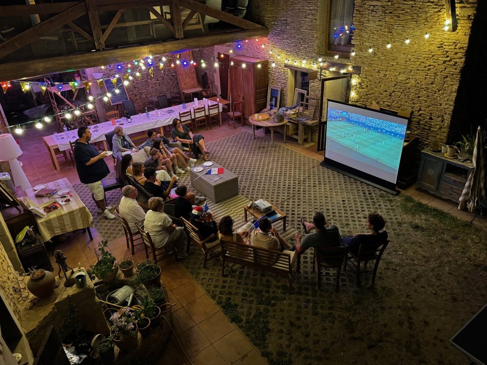 Soirée projection dans la cour illuminée de guirlandes, vue depuis l'étage