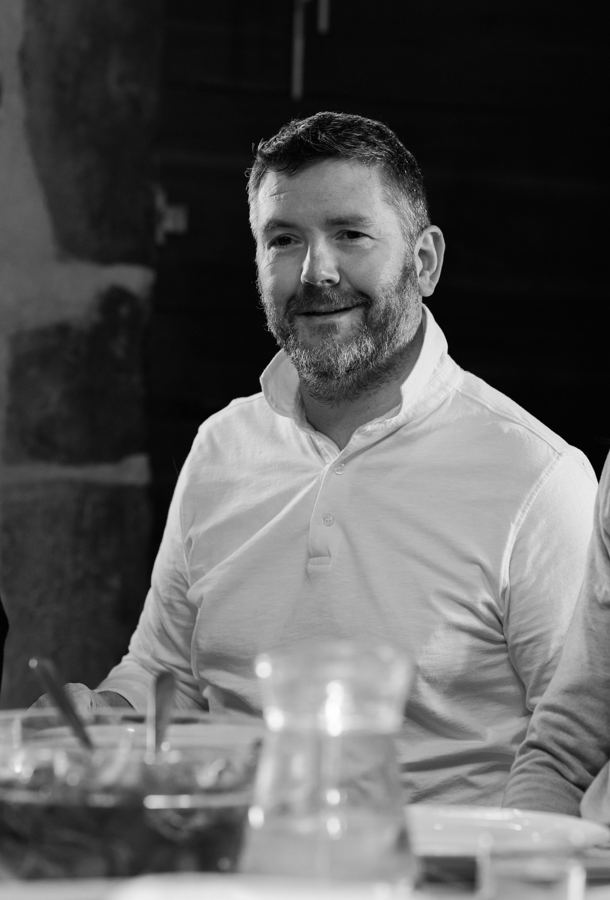 Portrait de Frédéric Angelot, souriant à table, en noir et blanc