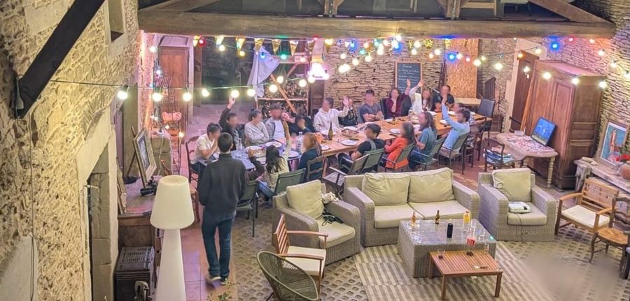 Une bande d'amis réunie le soir dans la cour illuminée de guirlandes