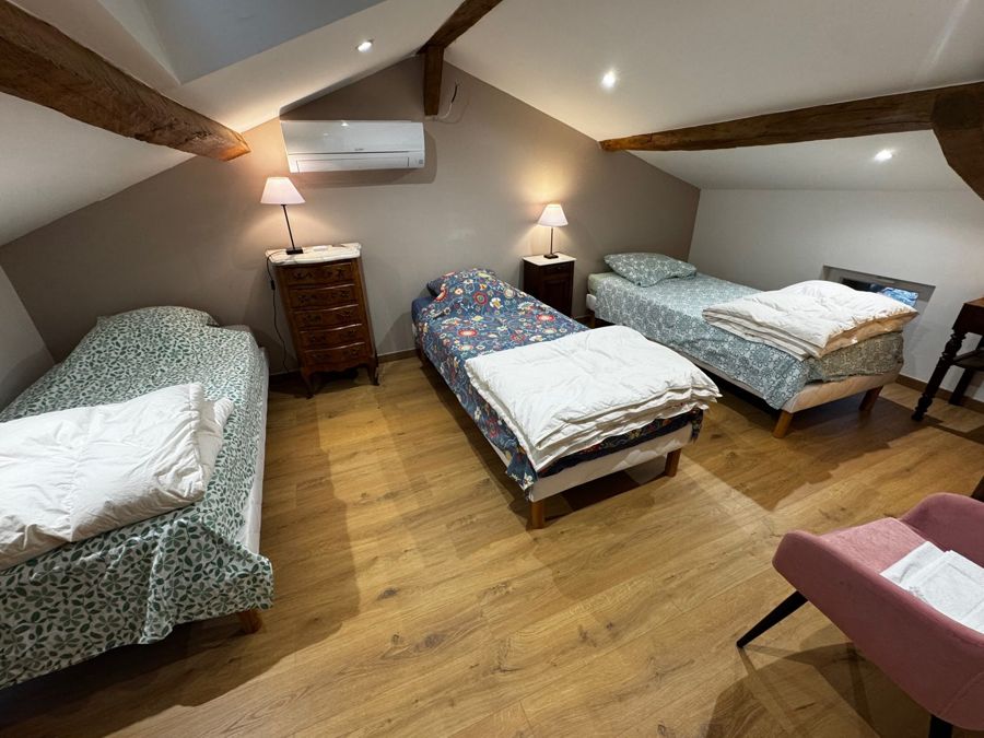 Chambre de trois lits sous les poutres, prête à accueillir