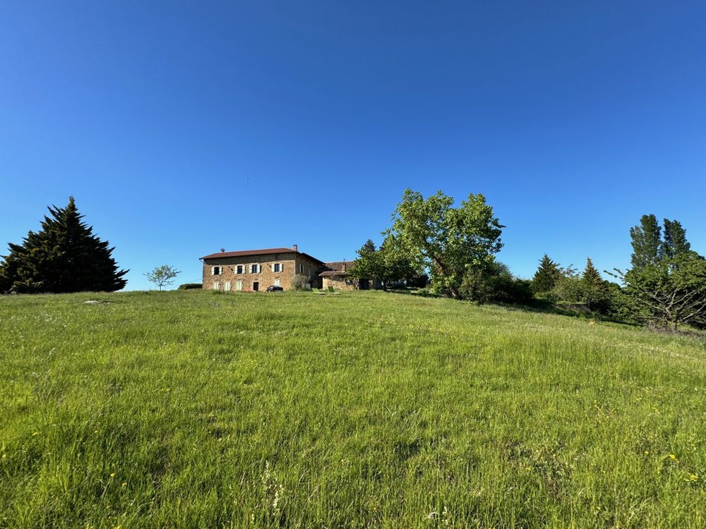 La grande prairie en pente, la maison au sommet sous un ciel bleu profond
