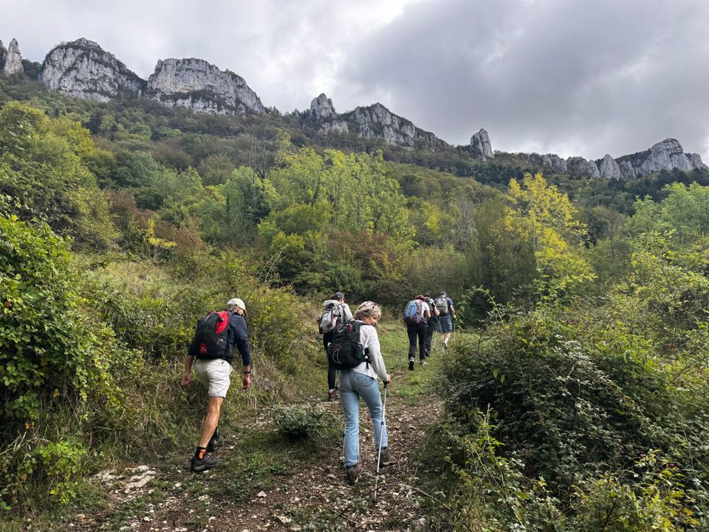 Des randonneurs montent un sentier vers les aiguilles rocheuses du Vercors