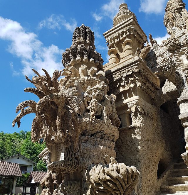 Sculptures et tours du Palais idéal du Facteur Cheval, sous un ciel bleu