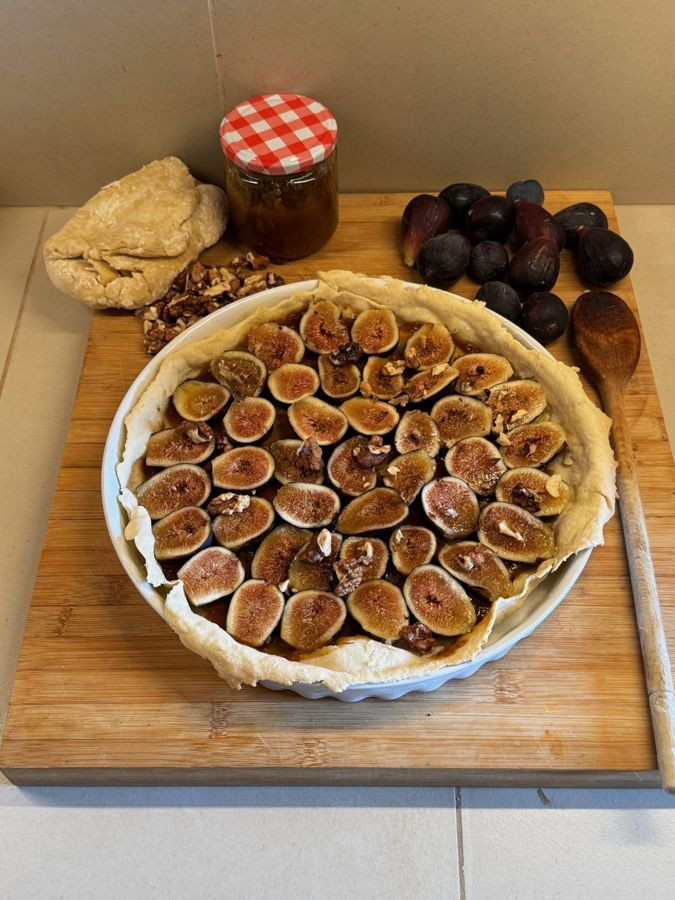 Tarte aux figues et aux noix avant cuisson, pot de miel et figues fraîches