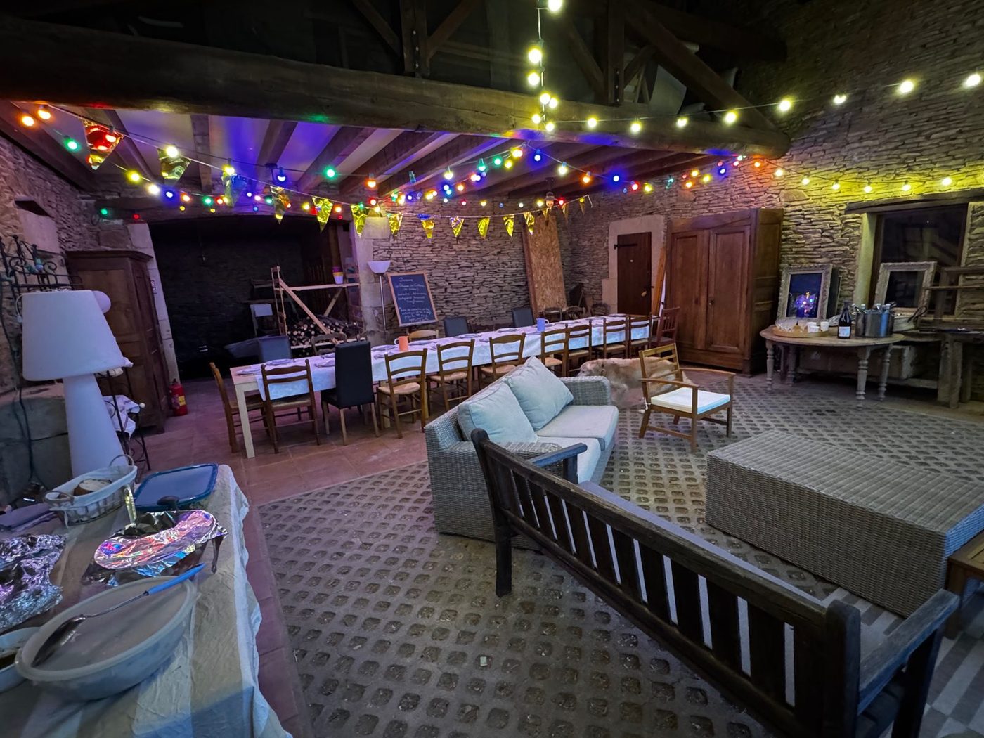 La cour couverte illuminée de guirlandes, salon et grande table dressée