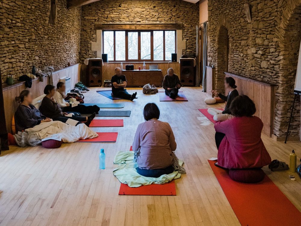 La grande salle en mode tapis : un groupe assis en cercle sur des coussins